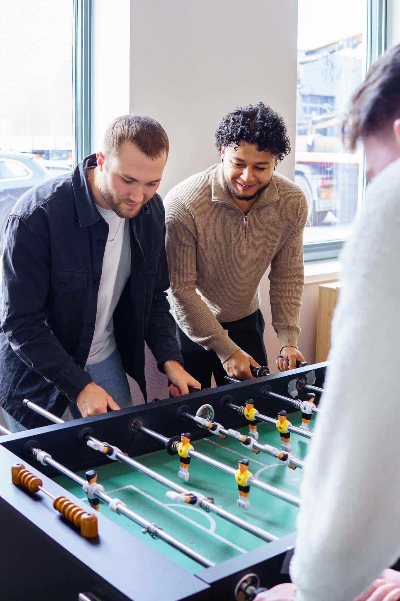 Collega's zijn aan het tafelvoetballen tijdens de lunchpauze