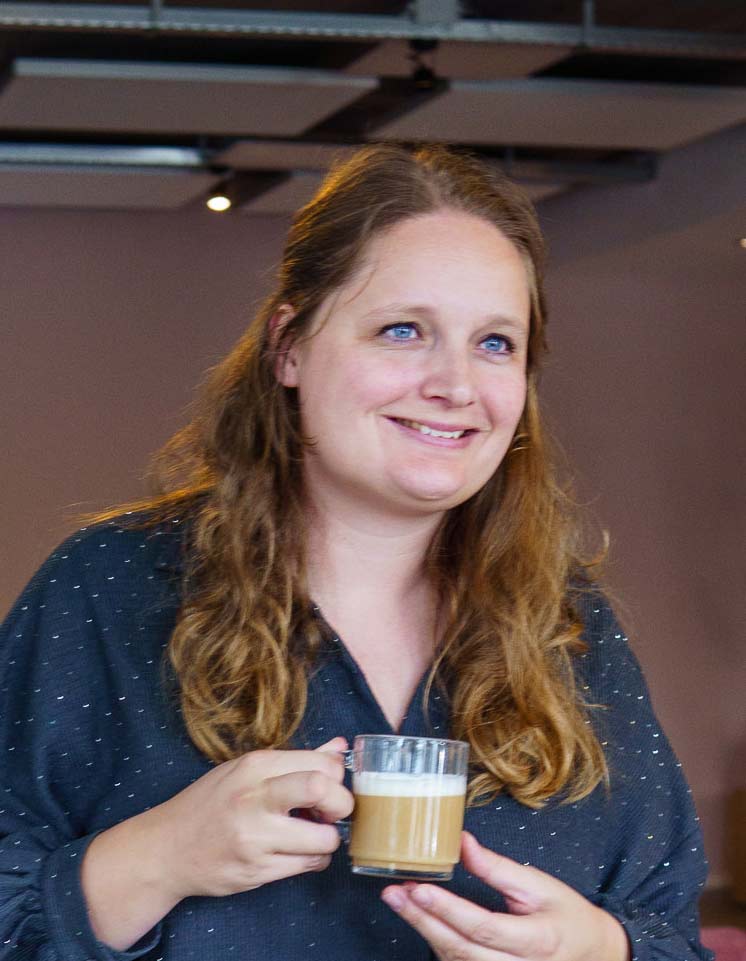 BURO210 Fullservice Marketingbureau Vrouw met een kop koffie, nadenkend over 'Wat is een conversie?'. Leer hoe je websitebezoekers overgaan tot een conversie, verhoog je online succes.