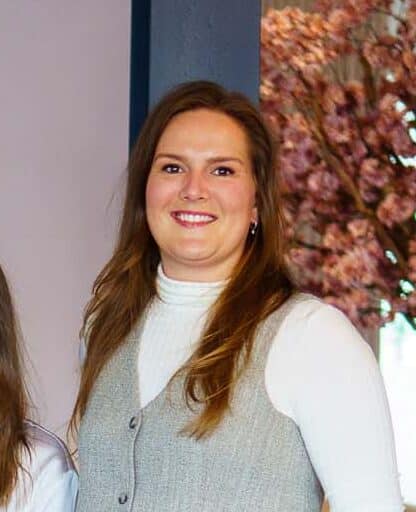 Twee strategisch adviseurs staan en zitten in een moderne kantoorruimte met de slogan gewoon goede marketing zichtbaar op de achtergrond.