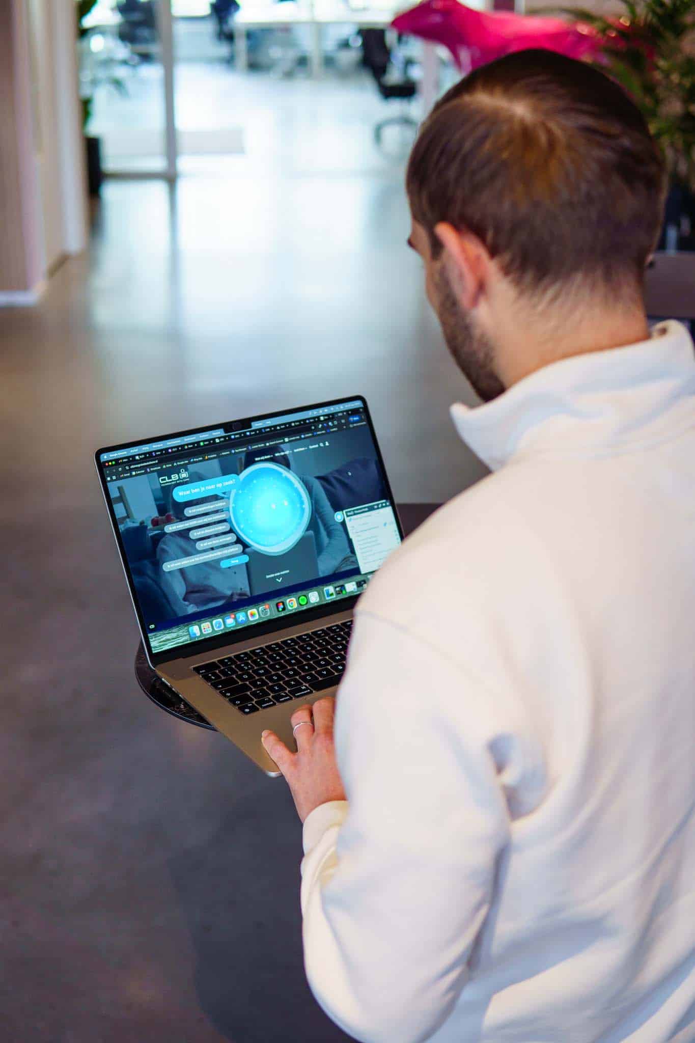 BURO210 Fullservice Marketingbureau Man bekijkt een laptop met de CLB-website in beeld, focus op jongerenwelzijn en begeleiding. Perfect voor blogs over onderwijs en mentale gezondheid.