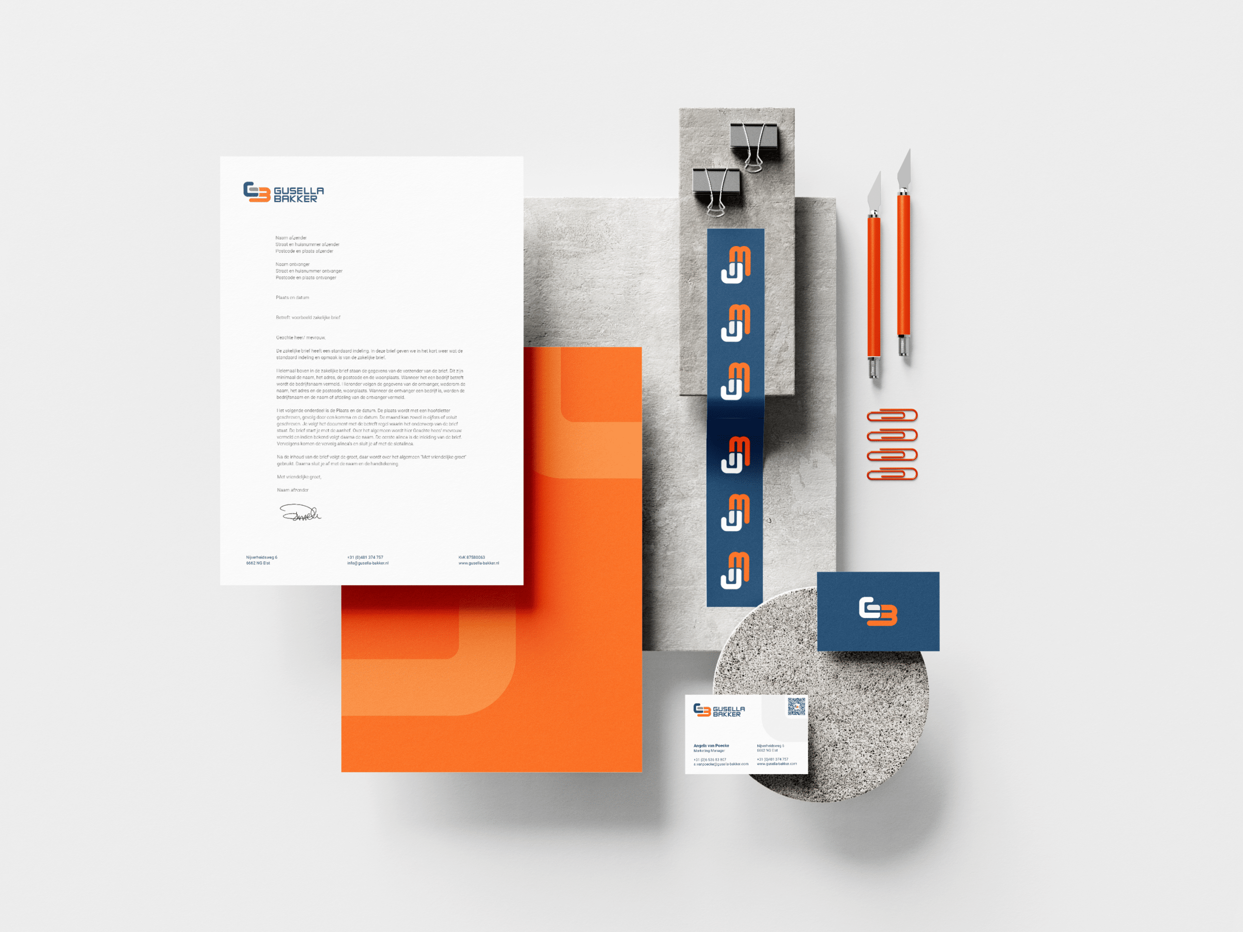 BURO210 Fullservice Marketingbureau Gestileerde flatlay van Gusella-Bakker branding materiaal, inclusief briefpapier, visitekaartjes en kantoorbenodigdheden in oranje en blauw. Een representatie van hun huisstijl.