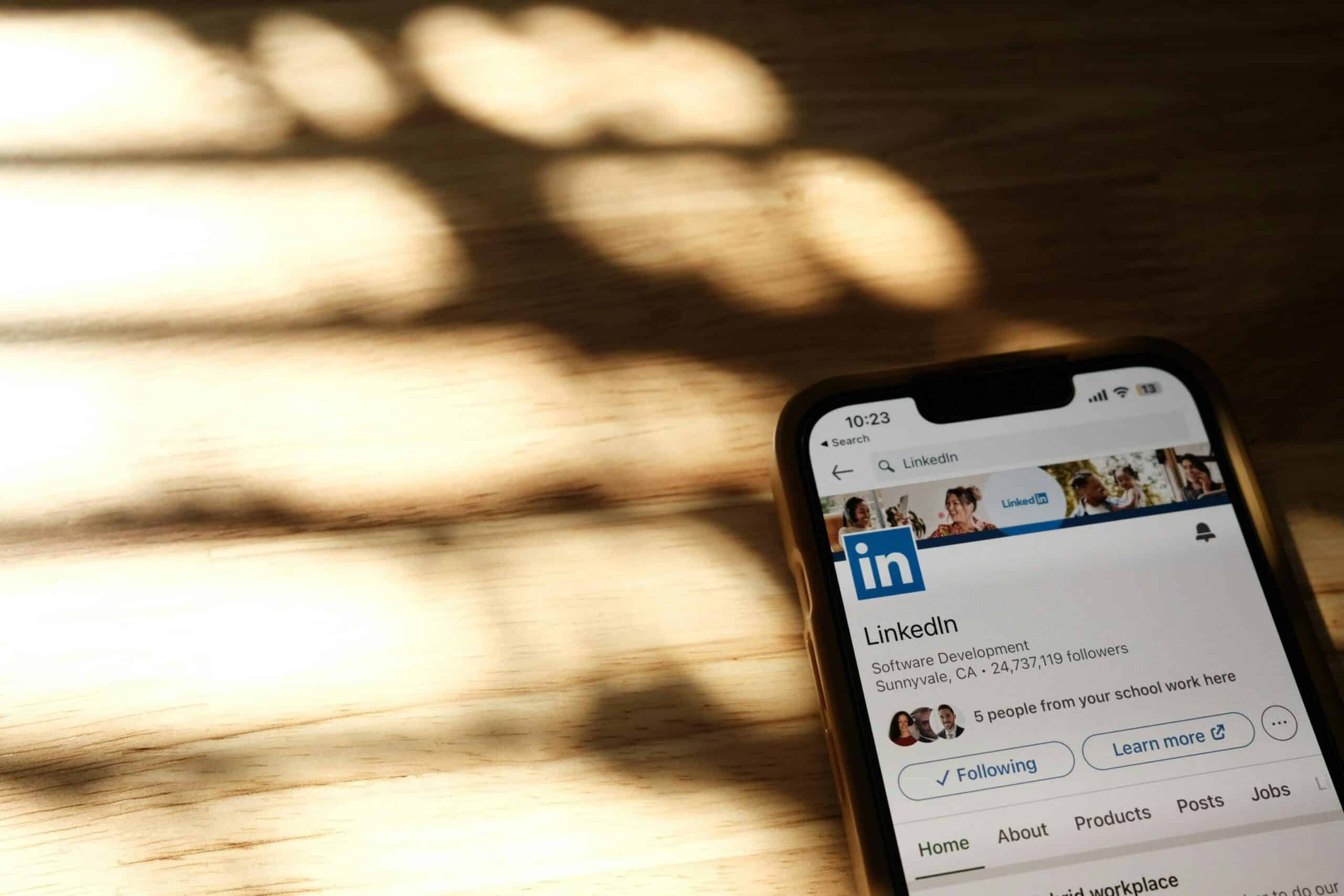BURO210 Fullservice Marketingbureau Close-up van een smartphone met de LinkedIn-app geopend, illustreert hoe je LinkedIn bereik vergroten kunt. Tips voor het verbeteren van je profiel en contentstrategie.