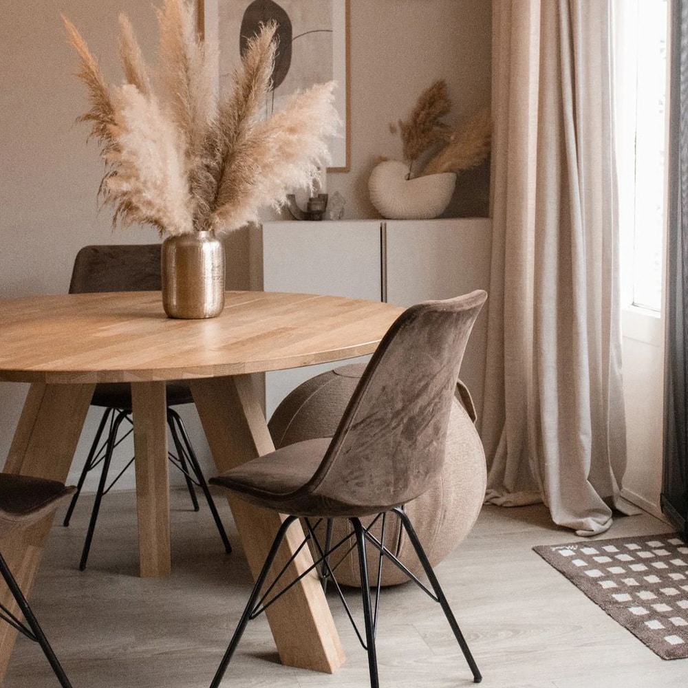 BURO210 Fullservice Marketingbureau Nederlandse eethoek met houten tafel, bruine stoelen en een vaas met pampasgras. Bekijk onze nieuwste kick collection voor inspiratie.